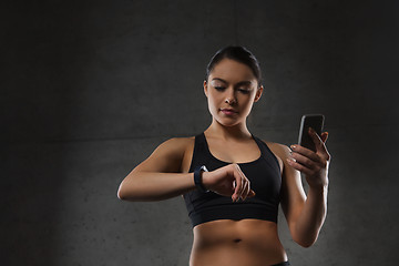 Image showing woman with heart-rate watch and smartphone in gym