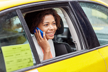 Image showing happy african woman calling on smartphone in taxi