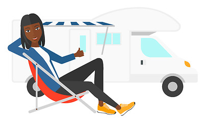 Image showing Woman sitting in front of motorhome.