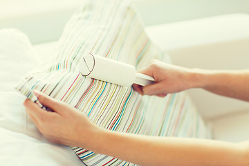 Image showing close up of woman hand with sticky roller cleaning