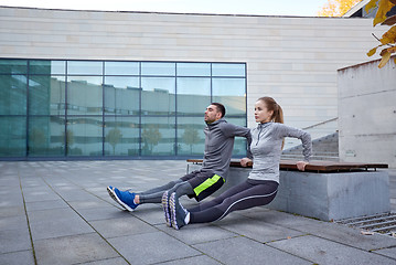 Image showing couple doing triceps dip exercise outdoors