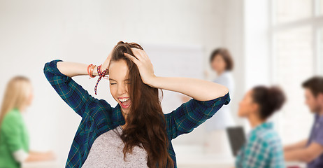 Image showing happy student girl holding to head at school