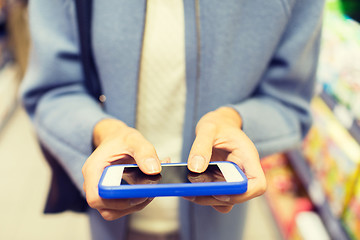 Image showing close up of woman with smartphone in market