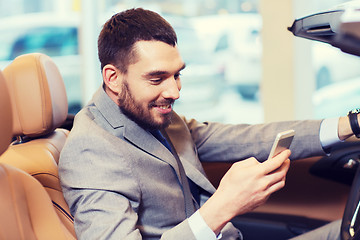 Image showing happy man sitting in car at auto show or salon