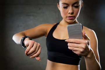 Image showing woman with heart-rate watch and smartphone in gym