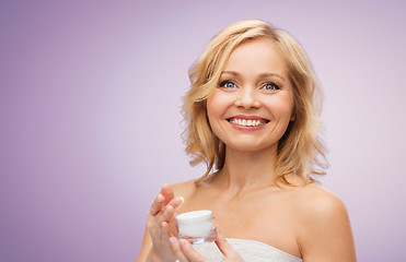 Image showing happy middle aged woman with cream jar