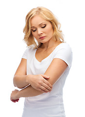 Image showing unhappy woman suffering from pain in hand