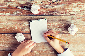 Image showing close up of hands with notebook and pencil