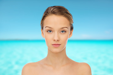 Image showing young woman face over blue sea nd sky
