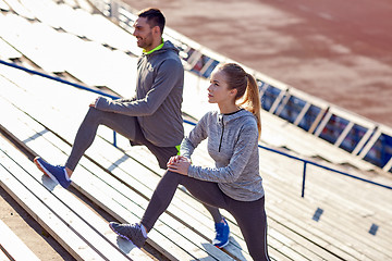 Image showing couple stretching leg on stands of stadium