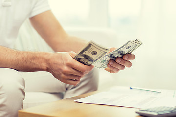 Image showing close up of man hands counting money at home