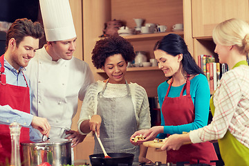 Image showing happy friends and chef cook cooking in kitchen