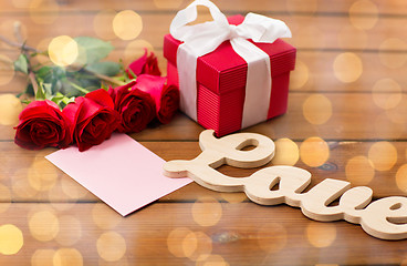 Image showing close up of gift box, red roses and greeting card