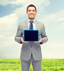 Image showing happy businessman in suit showing tablet pc screen