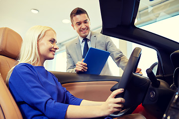 Image showing happy woman with car dealer in auto show or salon