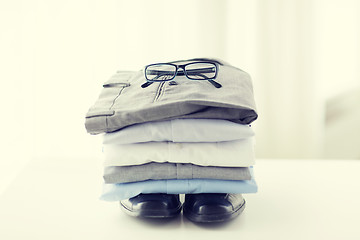 Image showing close up of folded male shirts and shoes on table