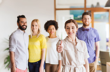 Image showing woman showing thumbs up over creative office team
