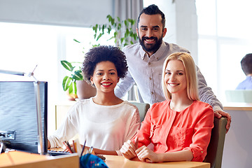 Image showing happy creative team with computer in office