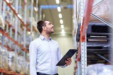 Image showing happy businessman with clipboard at warehouse