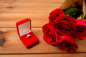 Image showing close up of diamond engagement ring and red roses