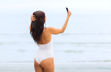 Image showing young woman taking selfie with smartphone