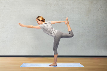 Image showing woman making yoga in lord of the dance pose on mat