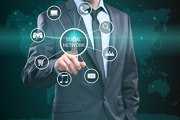 Image showing business, technology, internet and networking concept - businessman pressing button with Social Network on virtual screens. 