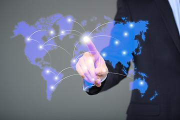 Image showing businessman touching a world map on the screen showing global connection between different continents.