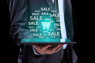 Image showing Businessman hand touch online shopping icons on a tablet. sale