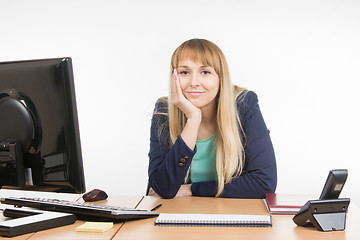 Image showing A little bit tired business woman behind a desk