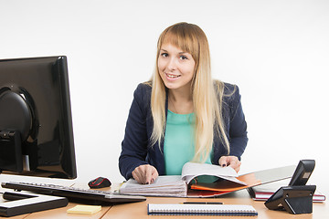 Image showing Business woman looks through documents in the folder and looked into the frame