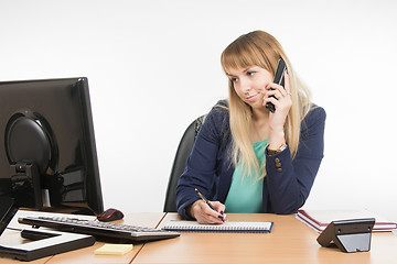 Image showing Unhappy business woman answering the phone looking at the screen