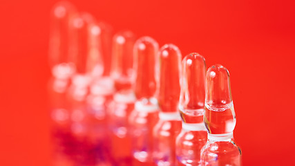 Image showing Medical ampules on a red background, selective focus. 