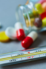 Image showing Mercury thermometer and medical pills on background