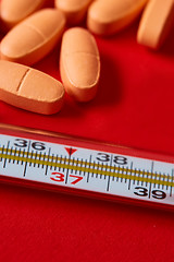 Image showing Mercury thermometer and medical pills on background