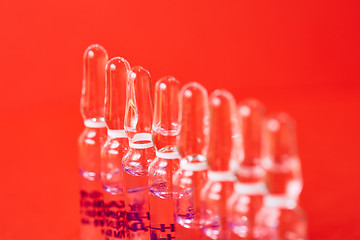 Image showing Medical ampules on a red background, selective focus. 