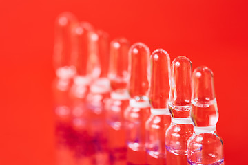 Image showing Medical ampules on a red background, selective focus. 