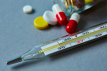 Image showing Mercury thermometer and medical pills on background