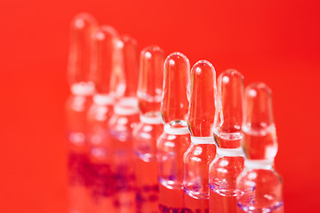 Image showing Medical ampules on a red background, selective focus. 
