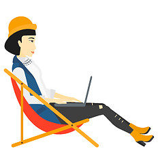 Image showing Business woman sitting in chaise lounge with laptop.