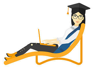 Image showing Graduate lying in chaise lounge with laptop.