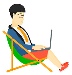 Image showing Businessman sitting in chaise lounge with laptop.