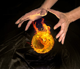 Image showing burning crystal ball and hands