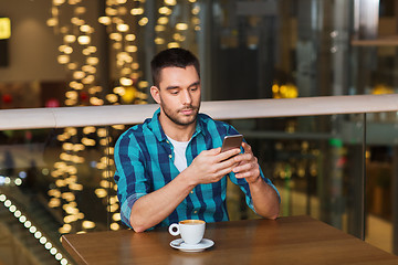 Image showing man with smartphone and coffee at restaurant