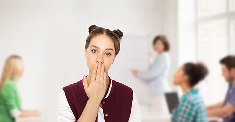 Image showing confused student girl covering her mouth by hand