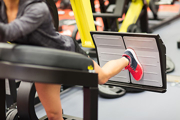 Image showing woman flexing muscles on leg press machine in gym