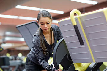 Image showing young woman adjusting leg press machine in gym