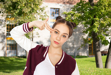 Image showing bored teenage girl making finger gun gesture