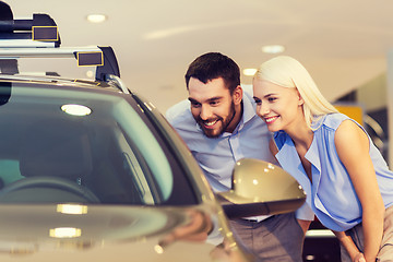 Image showing happy couple buying car in auto show or salon