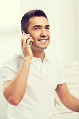 Image showing happy man calling on smartphone at home